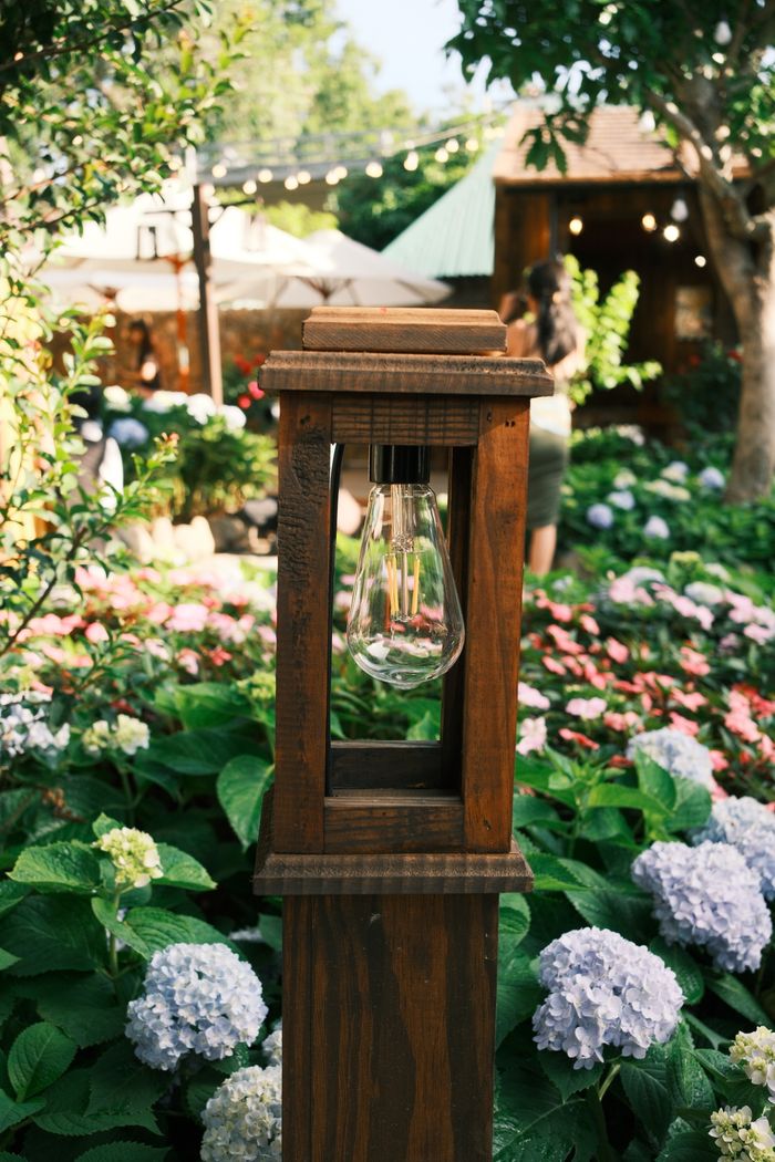 The Art of Drawing Readers In: Your attractive post title goes here Wooden garden lamp surrounded by vibrant hydrangeas in a tranquil outdoor setting, capturing a serene summer ambiance.